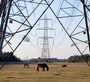 High voltage power transmission lines with pylons - iStockPhoto